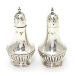 A pair of silver pepperettes with fluted decoration. Hallmarked Chester 1900, maker Colen Hewer