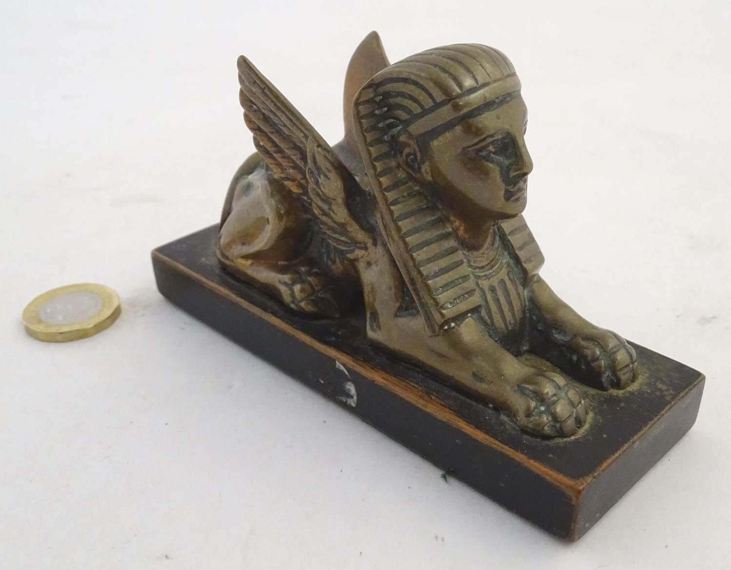 A 20thC paperweight formed as a winged sphinx with the head of a pharaoh on a rectangular wooden - Image 5 of 7