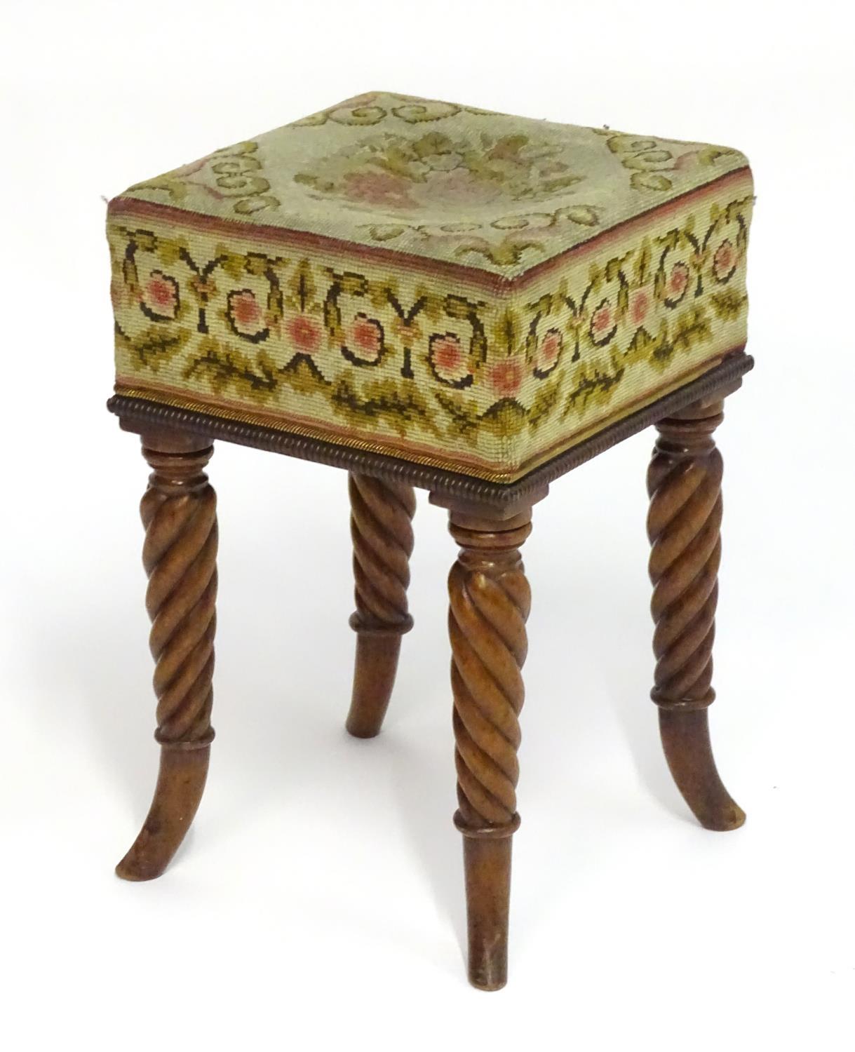 A Regency mahogany stool with a needlework squared top above four rope twist legs terminating in