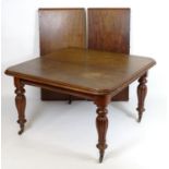 A mid / late 19thC mahogany extending dining table with a moulded top above reeded baluster legs