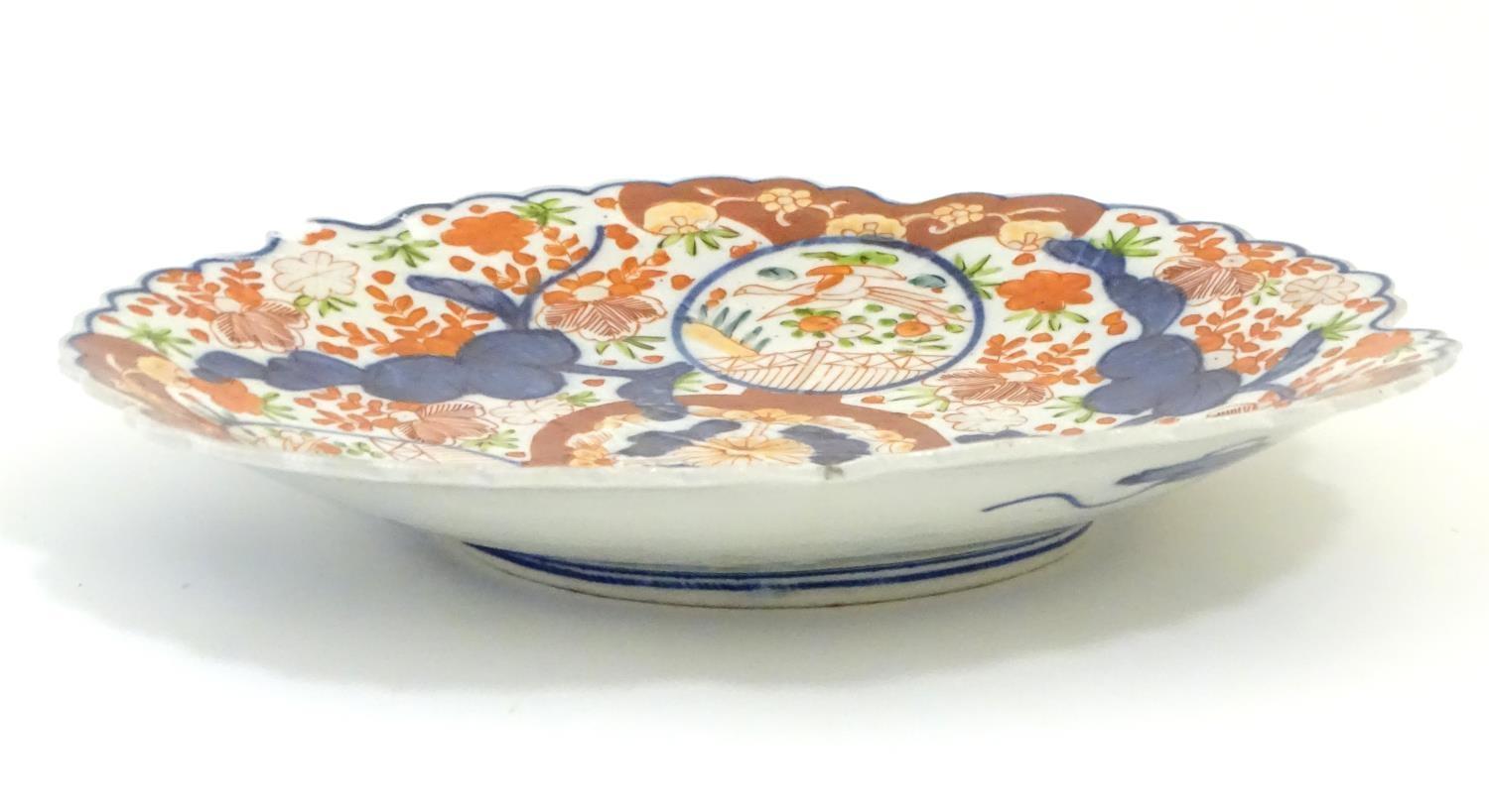 A Japanese Imari plate with a scalloped rim with stylised leaf veins in relief to the centre, - Image 3 of 9