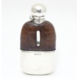 A Victorian glass hip flask with half leather covering, silver beaker lower and silver mounts.