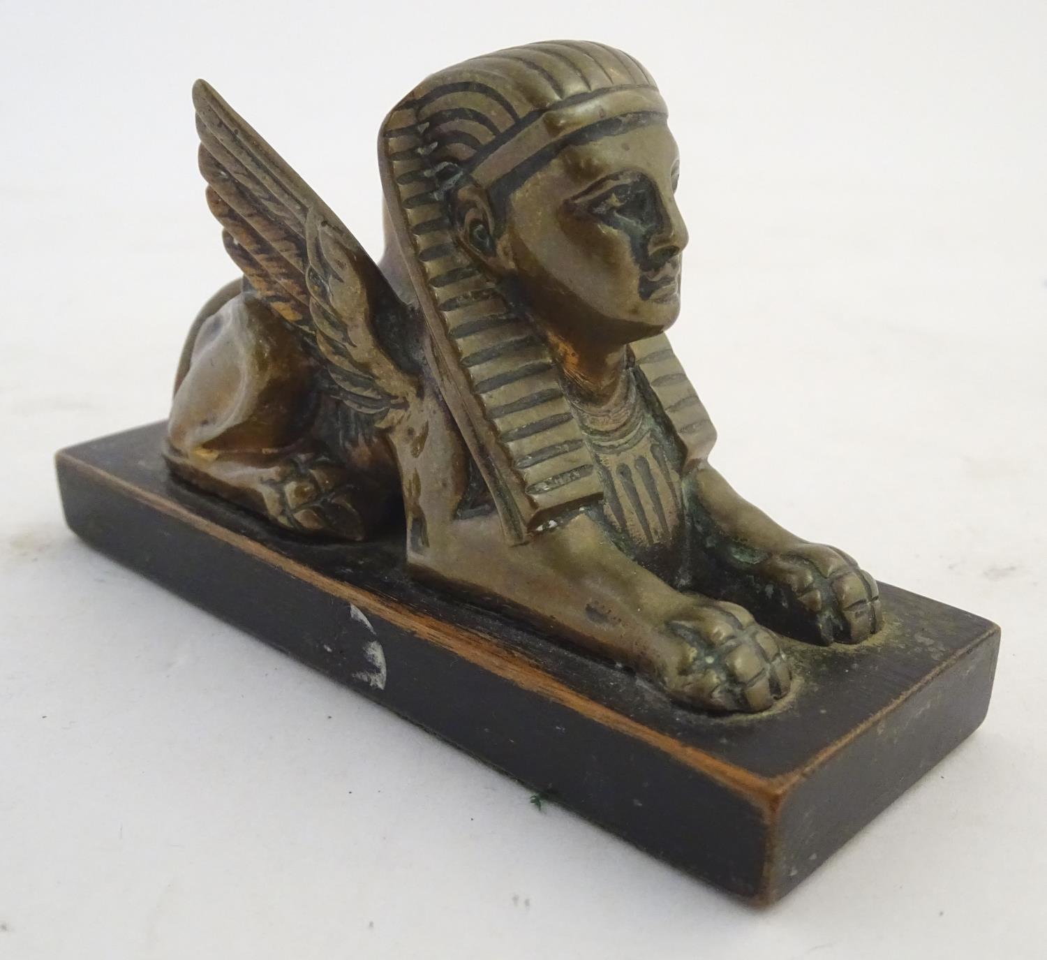 A 20thC paperweight formed as a winged sphinx with the head of a pharaoh on a rectangular wooden - Image 4 of 7
