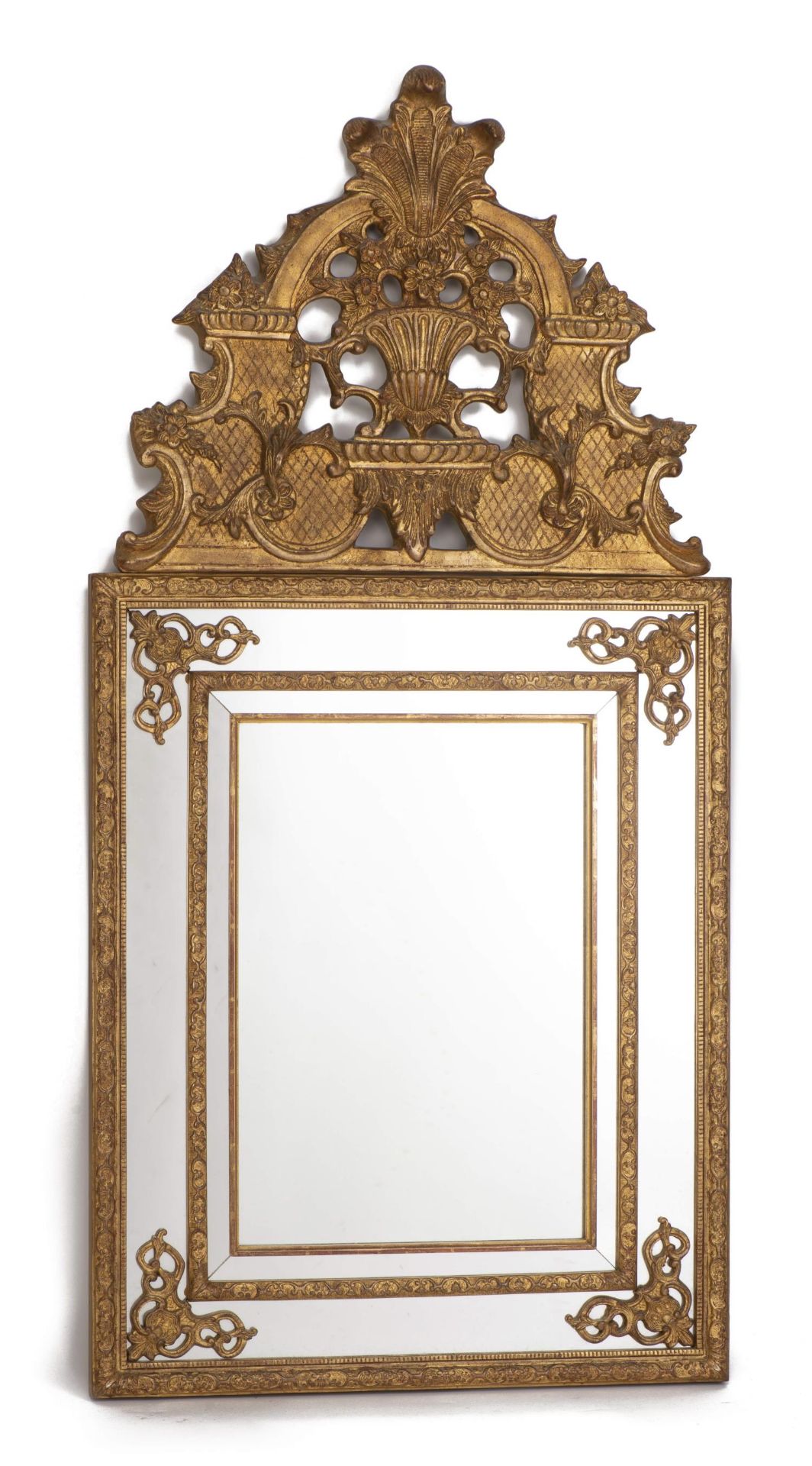 Miroir à parcloses en bois doré, mouluré et sculpté de feuillages, le fronton [...]