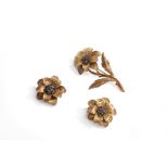 Paire de clips d'oreilles et broche à motif de fleurs en or .750 dont le pistil est [...]