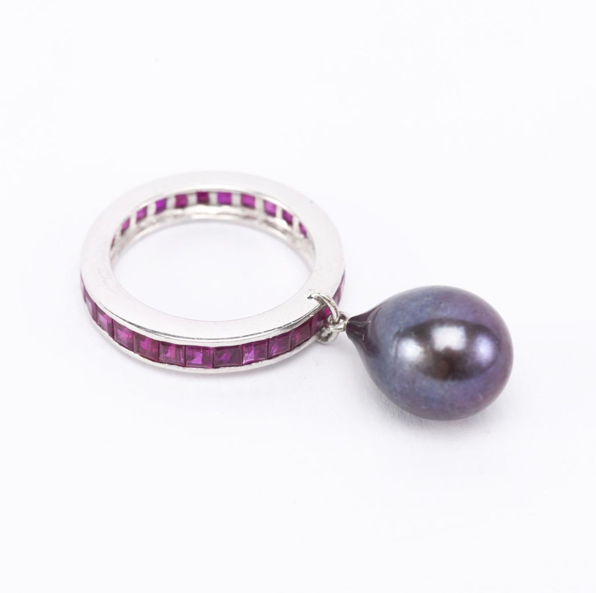 Bague anneau en or gris .750 rhodié, sertie de rubis carrés retenant une perle [...]