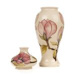 * Moorcroft. A Moorcroft pottery 'Magnolia' pattern vase and two others