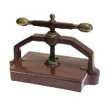 * Bookpress. A cast iron bookpress, finished in red, with brass handle ends & finial