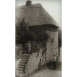 * Diapositive on glass. An elderly woman conversing with a neighbour outside her cottage, c. 1920