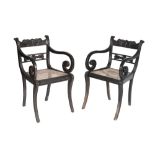 SET OF FOUR CARVED EBONNY AND CANEWORK ELBOW CHAIRS IN ANGLO-INDIAN EARLY 19TH CENTURY STYLE