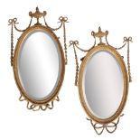 A PAIR OF ADAM STYLE GILTWOOD AND COMPOSITION FRAMED OVAL WALL MIRRORS,