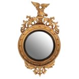 A REGENCY CARVED AND GILTWOOD FRAMED CONVEX WALL MIRROR,