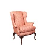 A CARVED MAHOGANY AND PINK DAMASK UPHOLSTERED WING ARMCHAIR IN GEORGE II STYLE,