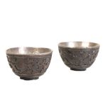 PAIR OF CARVED COCONUT AND SILVER LINED WINE CUPS, KANGXI PERIOD