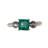 AN EMERALD AND DIAMOND THREE STONE RING