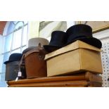 A VELVET LINED LEATHER TOP HAT BOX, two black top hats, a grey topper, a bowler hat and other hat