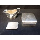 A SILVER CIGARETTE BOX, a silver engine turned match case and a silver milk jug (c.3.3oz)