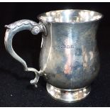 A SILVER MUG, London, 1930, baluster form with leaf-capped scroll handle, 9cm high (c.5.8oz)