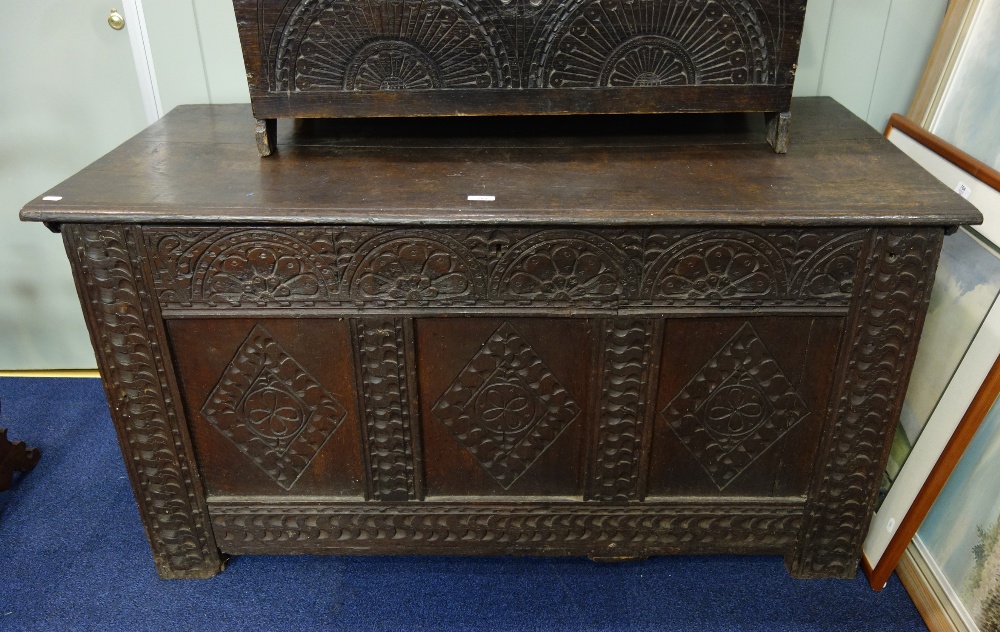 AN OAK PANELLED COFFER with carved decoration, 131cm wide