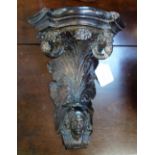 A 19TH CENTURY CONTINENTAL CARVED WALNUT CORBEL with foliage and scrolls emerging from a head