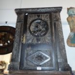 A 19TH CENTURY OAK AND WALNUT CUPBOARD made from carved pieces, including a 'Romayne' head, 60cm