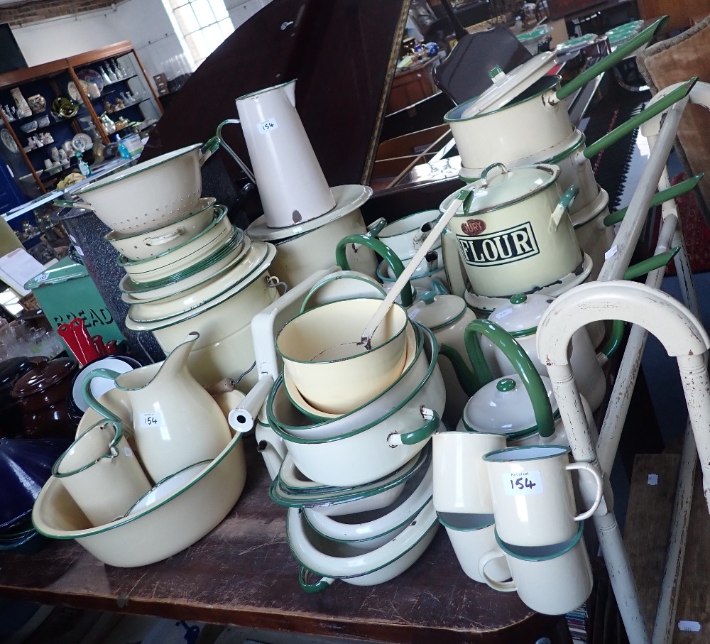 A LARGE COLLECTION OF VINTAGE CREAM AND GREEN ENAMEL KITCHENALIA