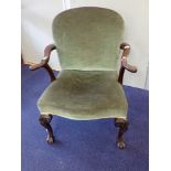 A CARVED WALNUT AND GREEN VELVET UPHOLSTERED ELBOW CHAIR IN GEORGE II STYLE, circa 1900, the