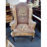 A GEORGE I STYLE WING ARMCHAIR with distressed upholstery on cabriole legs, 80cm wide