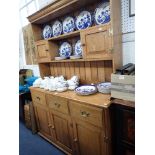 A REPRODUCTION OAK DRESSER, the rack fitted with two small cupboards, 140cm wide
