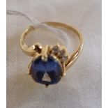 A TANZANITE AND DIAMOND RING, the oval-cut tanzanite, claw-set, flanked either side with three