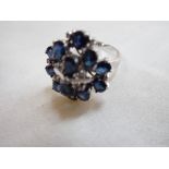 A SAPPHIRE AND DIAMOND CLUSTER RING, on a white gold shank stamped '585', ring size N-O