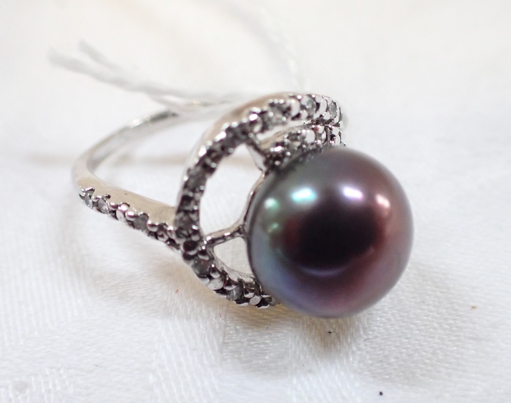 A BLACK SIMULATED PEARL DRESS RING, the pearl with green / mauve hues, on a silver shank, ring