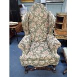 A WILLIAM AND MARY STYLE WING ARMCHAIR with half scrolling and turned legs and stretchers, 80cm