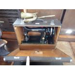 A VINTAGE SINGER SEWING MACHINE with rubber Singer mat and a brass car horn