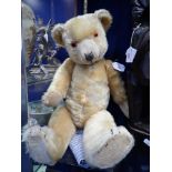 A VINTAGE PLUSH TEDDY BEAR, with jointed limbs, 55cm high, circa 1950s (or earlier) in need of a