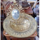 A CAST IRON AND GILT PAINTED FLORENTINE STYLE MIRROR and an embossed brass plaque