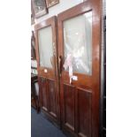 A PAIR OF EDWARDIAN WALNUT PANELLED DOORS, with later brass handles and glazed upper sections (one