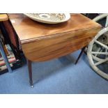 A REGENCY MAHOGANY PEMBROKE TABLE on turned legs with brass castor, 86cm wide