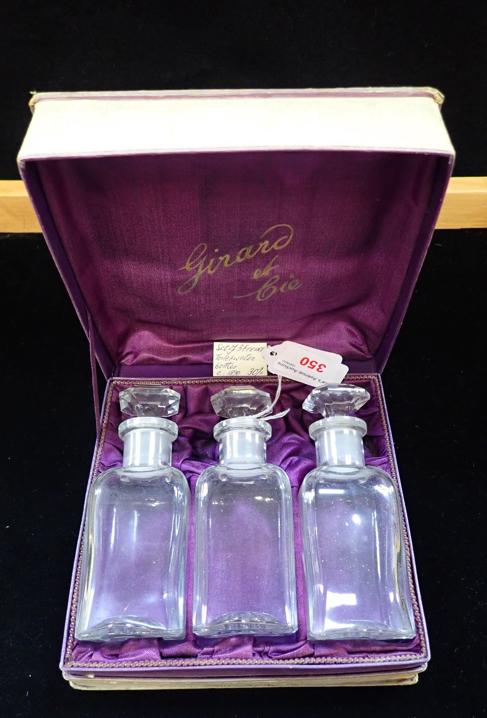 A SET OF THREE EARLY 20TH CENTURY GLASS TOILET WATER BOTTLES, in an original box