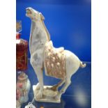 A SMALL TANG STYLE POTTERY HORSE, modelled with head raised and turned to one side, 29 cm high, with