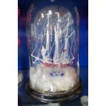 A VICTORIAN BLOWN GLASS 'FRIGGER' OF A SAILING SHIP, with another smaller and a lighthouse, under a