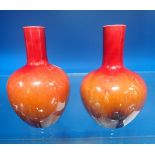 A PAIR OF RED AND BROWN FLAMBE GLAZED SQUAT BOTTLE VASES in the style of Burmantofts, 12cm high