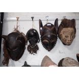 A COLLECTION OF CARVED WOODEN TRIBAL MASKS (4)