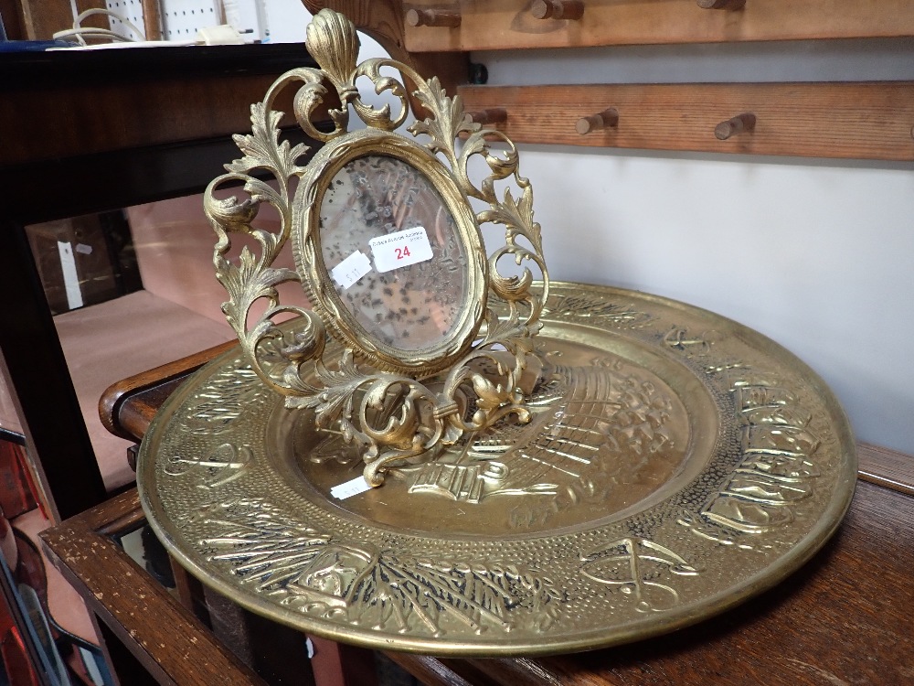 A CAST IRON AND GILT PAINTED FLORENTINE STYLE MIRROR and an embossed brass plaque