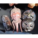 A COLLECTION OF CARVED WOODEN TRIBAL MASKS (4)