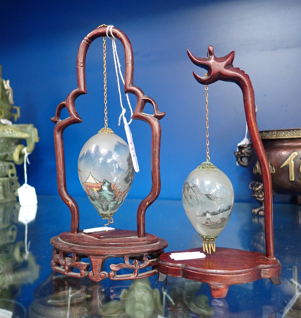 A CHINESE INTERIOR PAINTED GLASS HANGING EGG, on a hardwood stand and another similar (2)