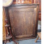 A 19TH CENTURY PINE HANGING CORNER CUPBOARD, the single panelled door enclosing shelves with old pai