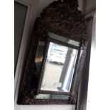A DUTCH STYLE REPOUSSE BRASS FRAMED CUSHION MIRROR, 33cm wide