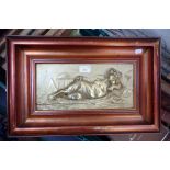 A CAST AND POLISHED BRASS PLAQUE depicting a reclining cherub, 17cm high x 35cm wide (within frame)