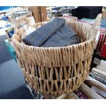 A COLLECTION OF THROWS and blankets contained in a woven basket